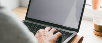 hand typing on laptop on desk