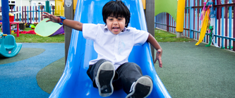 A boy going down a slide in a playground