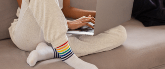 A person sitting on a sofa using their laptop