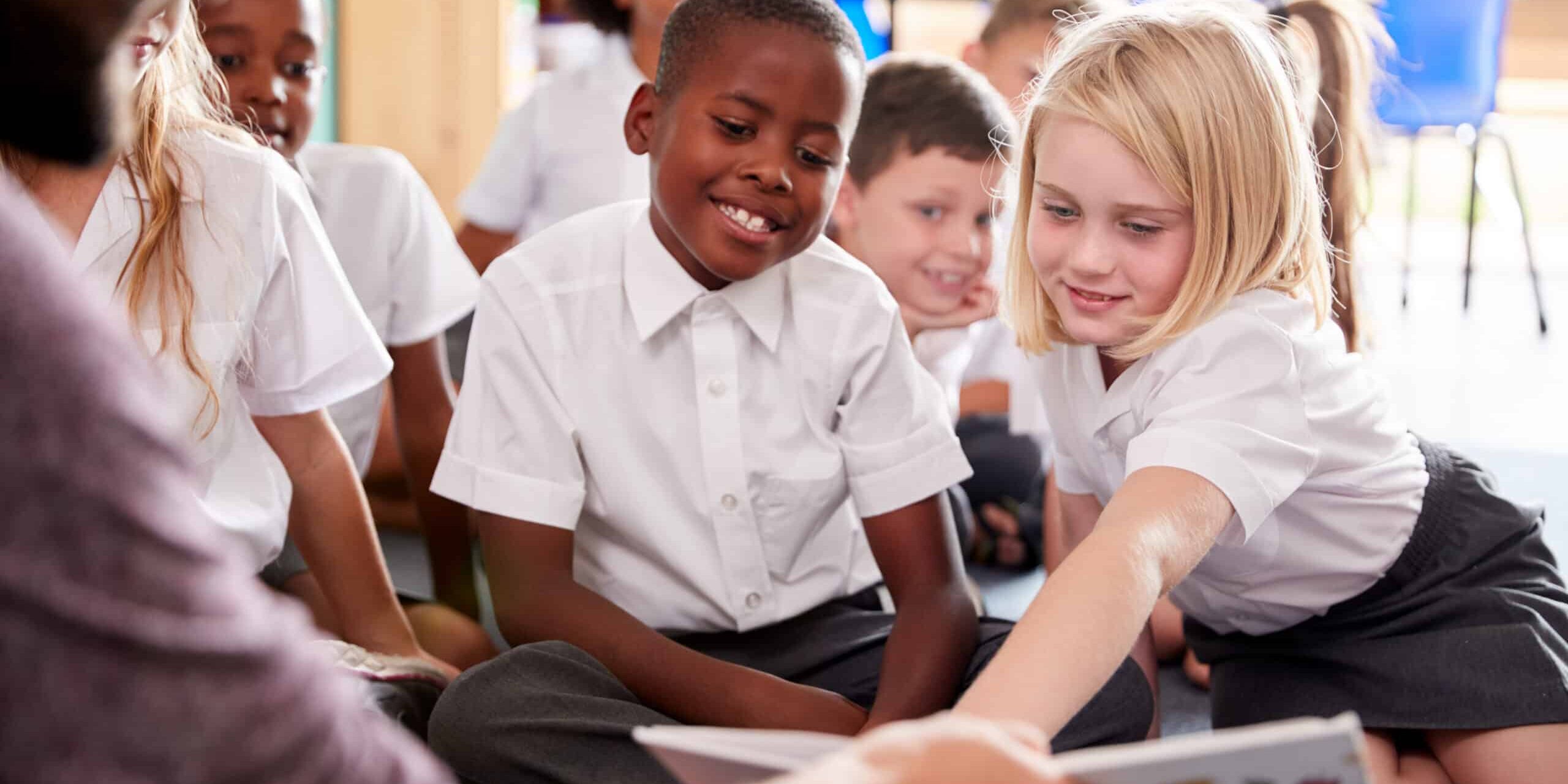 Male,Teacher,Reading,Story,To,Group,Of,Elementary,Pupils,Wearing